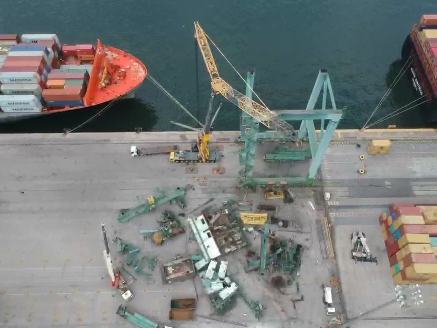 Vista aérea de terminal portuário com navio atracado e portêiner em desmontagem